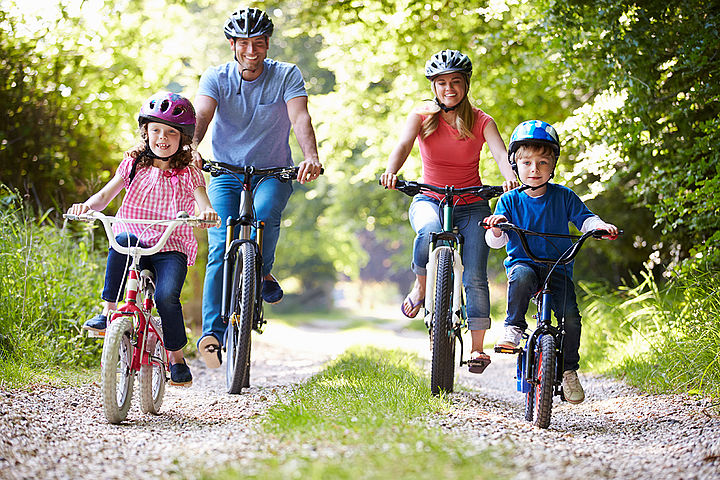 Familie fährt Fahrrad Familie fährt mit den Fahrrädern im Grünen