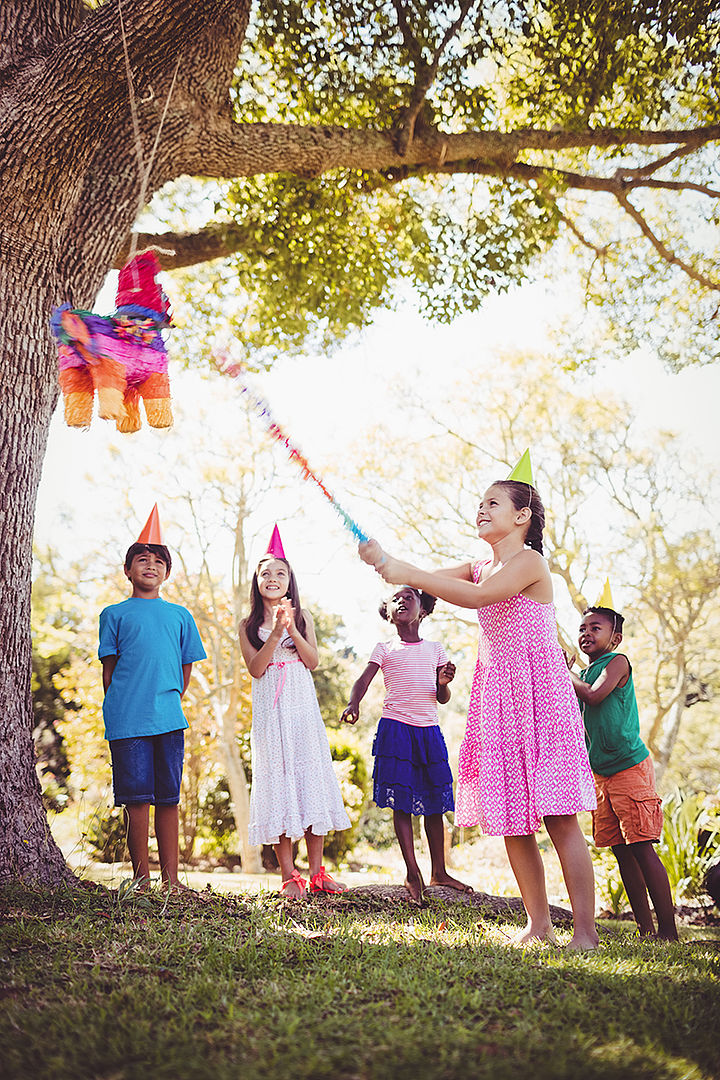 Piñata Spiel Kind schlägt mit Knüppel auf Piñata